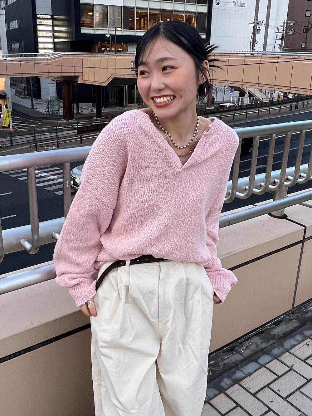 ホワイト系のチノパンツ、ピンク系のニット/セーター、ブラウン系のベルトを着用したレディースの冬コーディネートの5枚目の写真