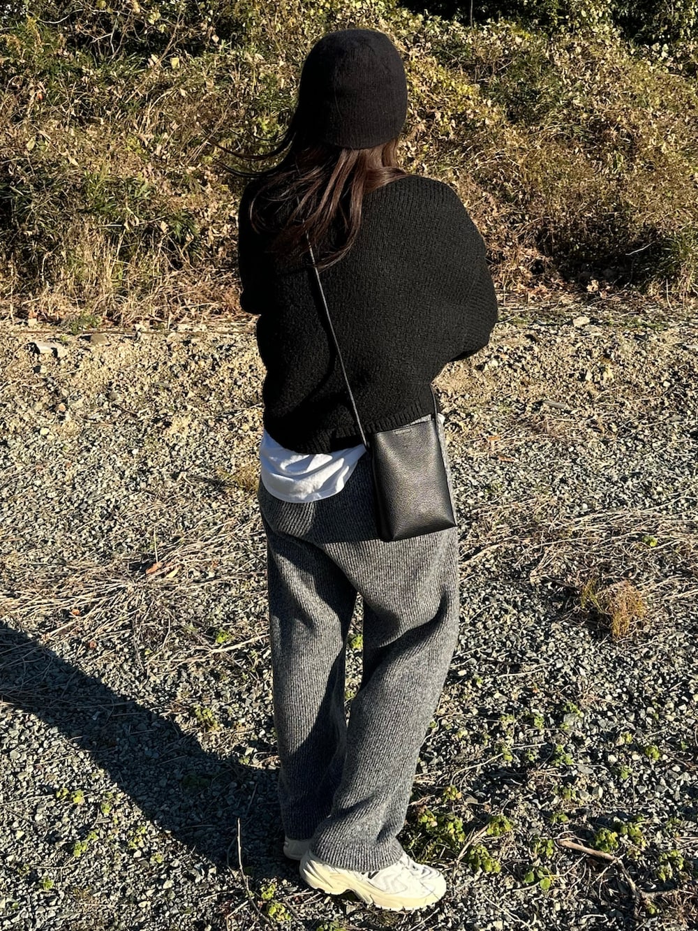 グレー系のその他パンツ、ホワイト系のTシャツ/カットソー、ブラック系のメガネを着用したレディースの冬コーディネートの3枚目の写真