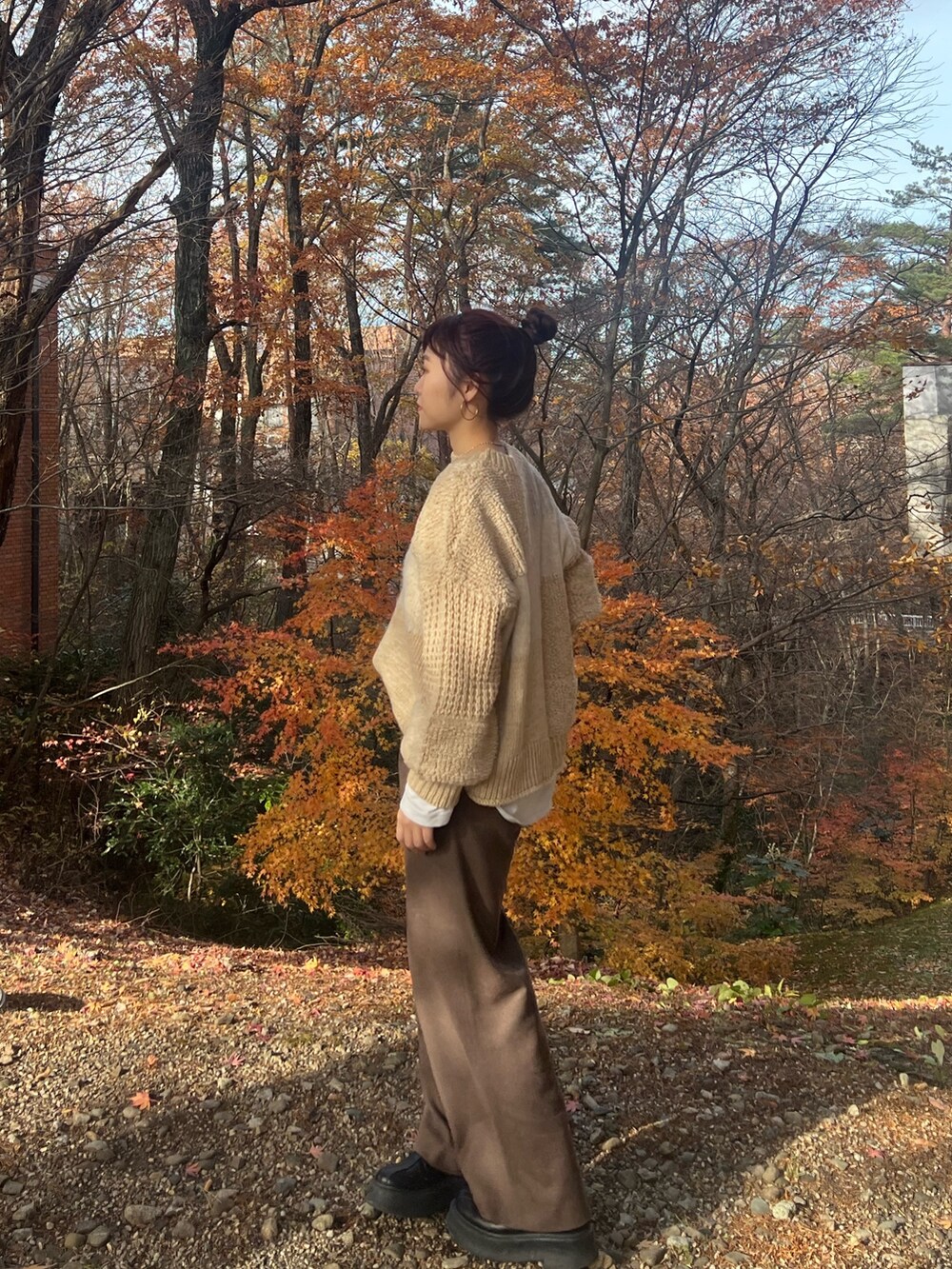 ホワイト系のニット/セーター、ブラウン系のその他パンツ、ブラック系のブーツを着用したレディースの冬コーディネートの4枚目の写真