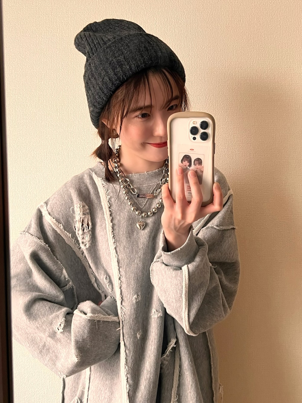 グレー系のスウェット、グレー系のニットキャップ/ビーニー、シルバー系のネックレスを着用したレディースの冬コーディネートの2枚目の写真