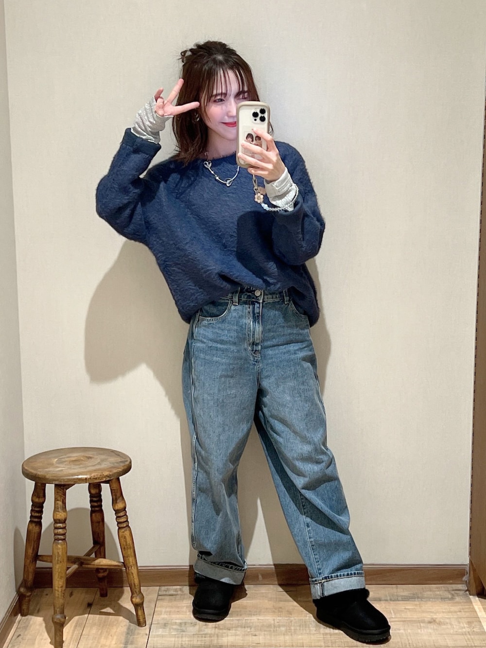 ブルー系のニット/セーター、ブルー系のデニムパンツ、ブラック系のモカシン/デッキシューズを着用したレディースの冬コーディネートの2枚目の写真