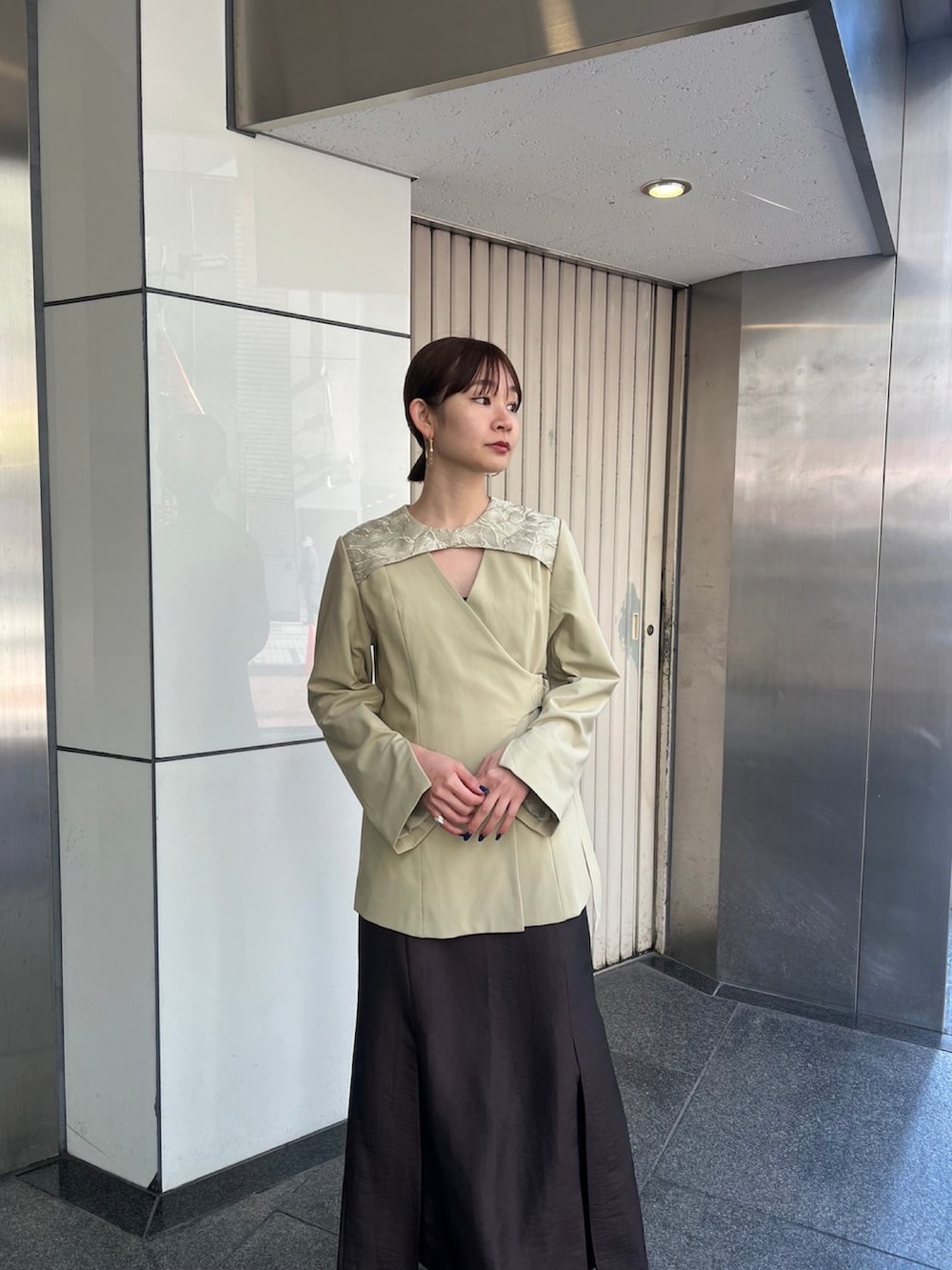 ブラウン系のスカート、グリーン系のその他アウターを着用したレディースの冬コーディネートの2枚目の写真