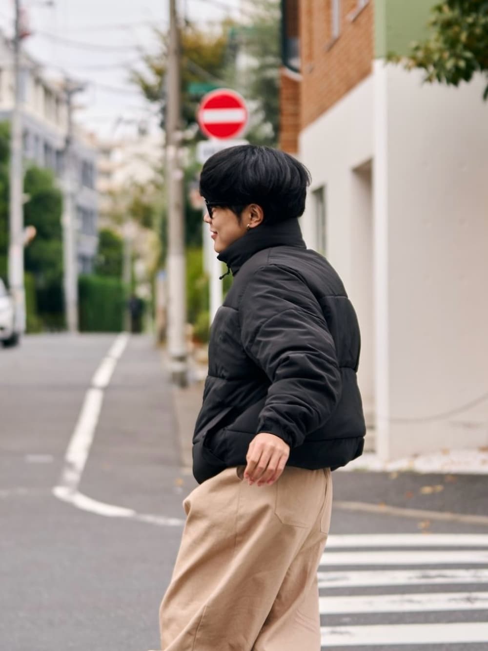 ブラック系のダウンジャケット/コート、ホワイト系のチノパンツ、ブラウン系のモカシン/デッキシューズを着用したメンズの秋コーディネートの2枚目の写真