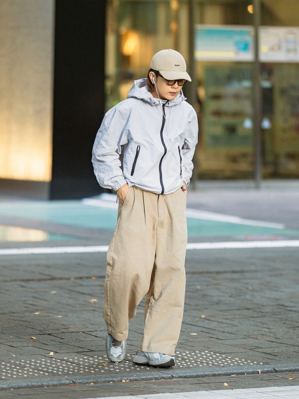ブラック系のマウンテンパーカー、ベージュ系のチノパンツ、グレー系のスニーカーを着用したメンズの秋コーディネートの4枚目の写真
