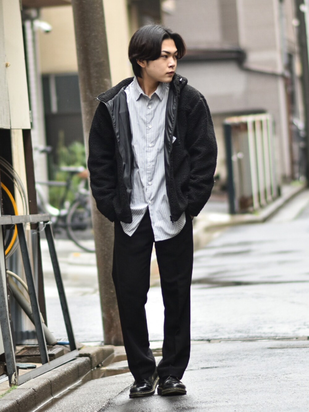 ブラック系のブルゾン、ブラック系のスラックス、ブラック系のローファーを着用したメンズの冬コーディネートの2枚目の写真