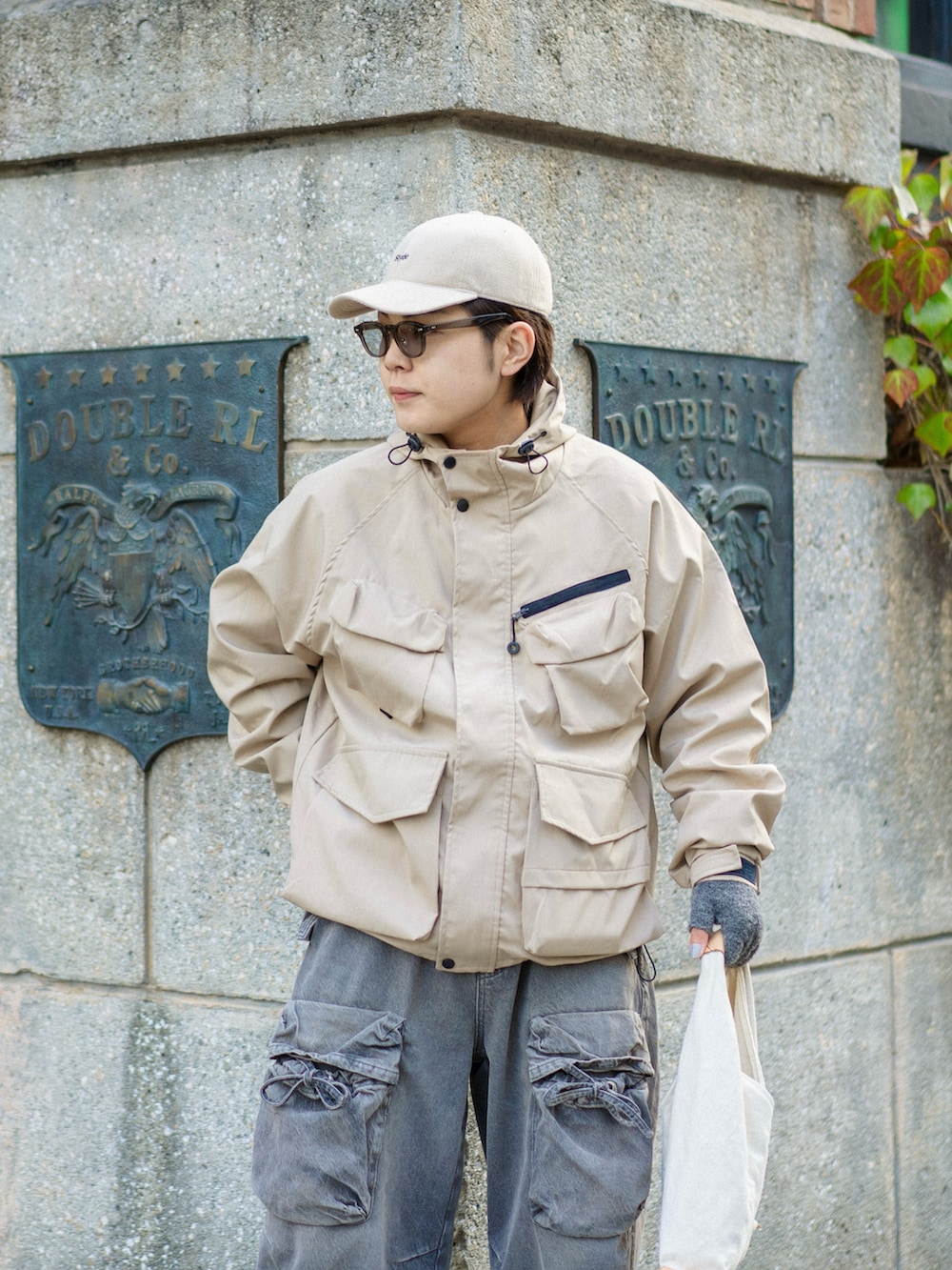 ベージュ系のマウンテンパーカー、ホワイト系のスニーカー、ベージュ系のトートバッグを着用したメンズの冬コーディネートの2枚目の写真