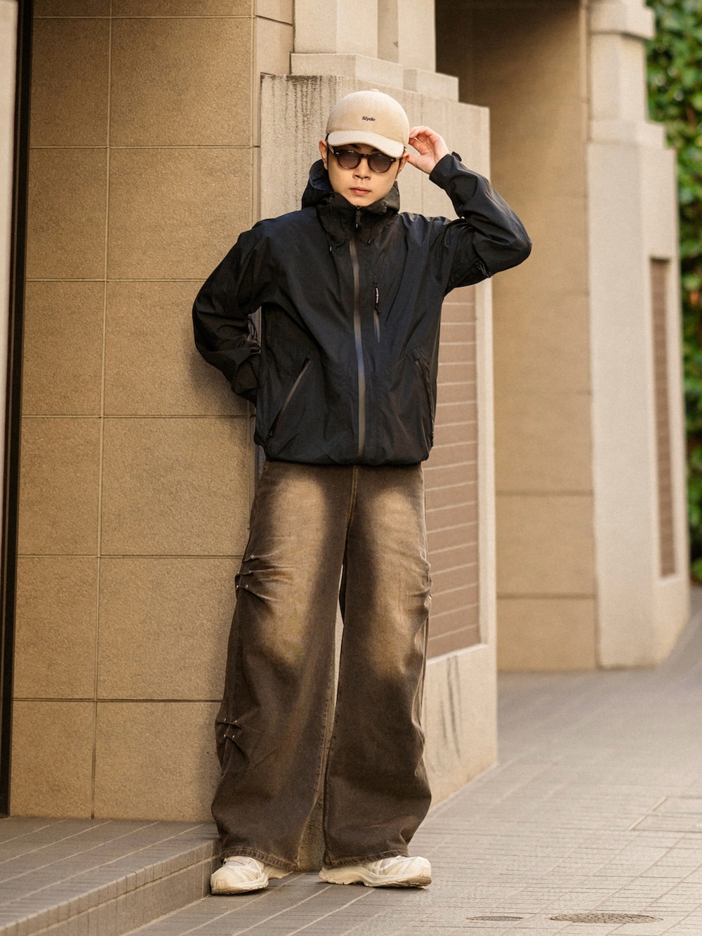 ブラック系のデニムパンツ、ホワイト系のスニーカー、ベージュ系のキャップを着用したメンズの冬コーディネートの2枚目の写真
