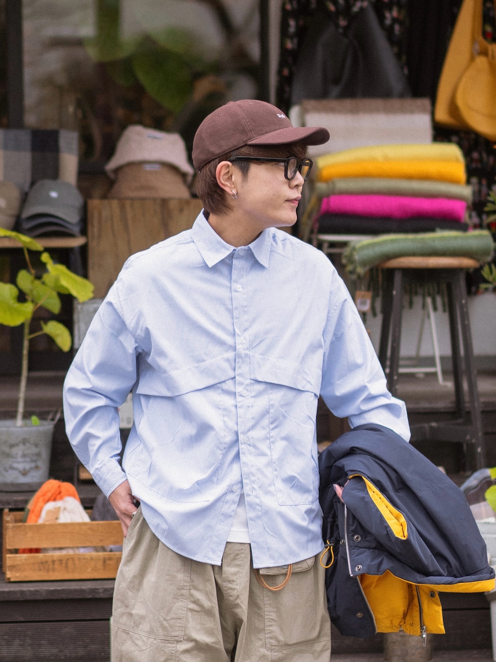 ブルー系のダウンベスト、グレー系のスニーカー、ブラウン系のキャップを着用したメンズの冬コーディネートの3枚目の写真