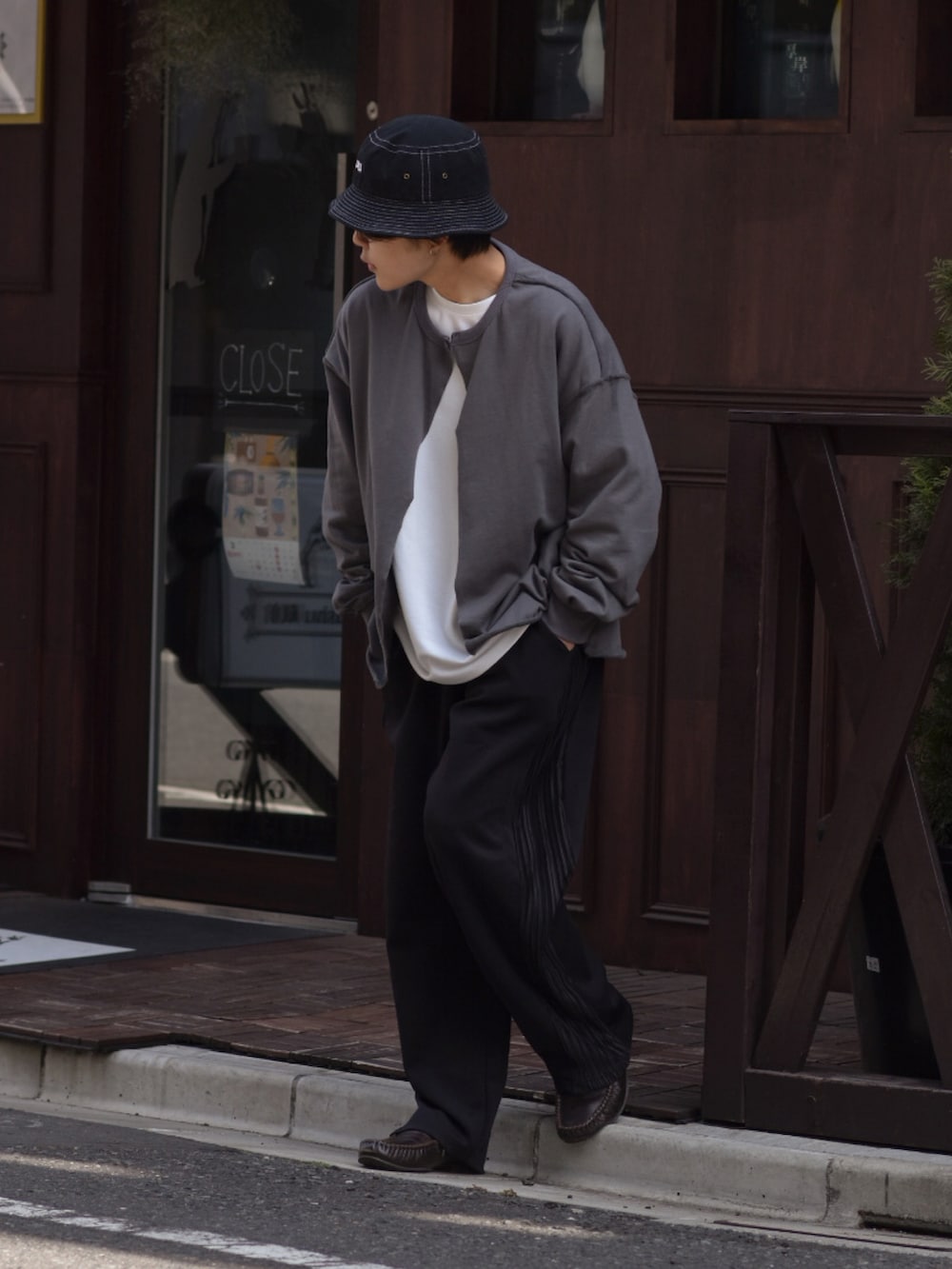 ホワイト系のTシャツ/カットソー、グレー系のカーディガン/ボレロ、ブラック系のパンツを着用したメンズの春コーディネートの2枚目の写真