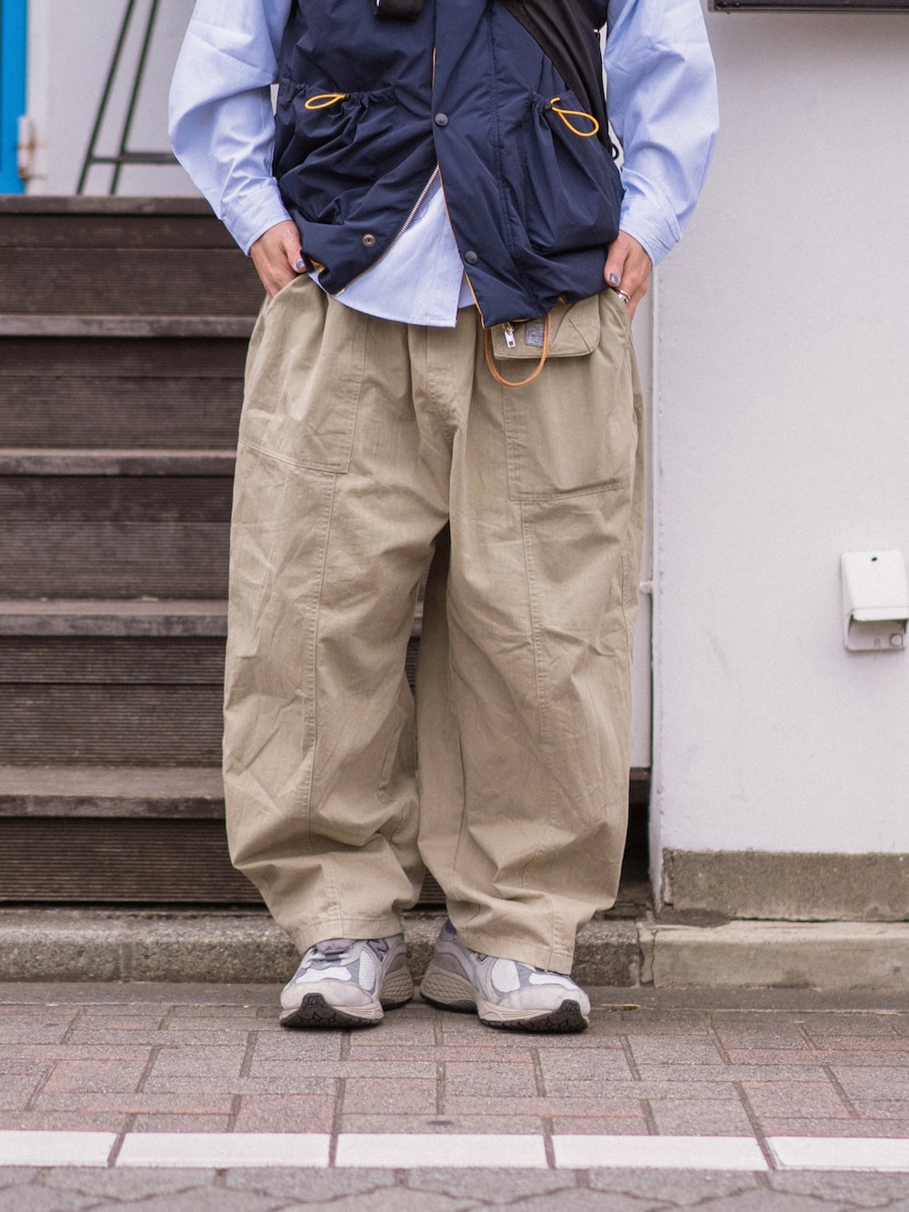 ブルー系のダウンベスト、グレー系のスニーカー、ブラウン系のキャップを着用したメンズの冬コーディネートの4枚目の写真