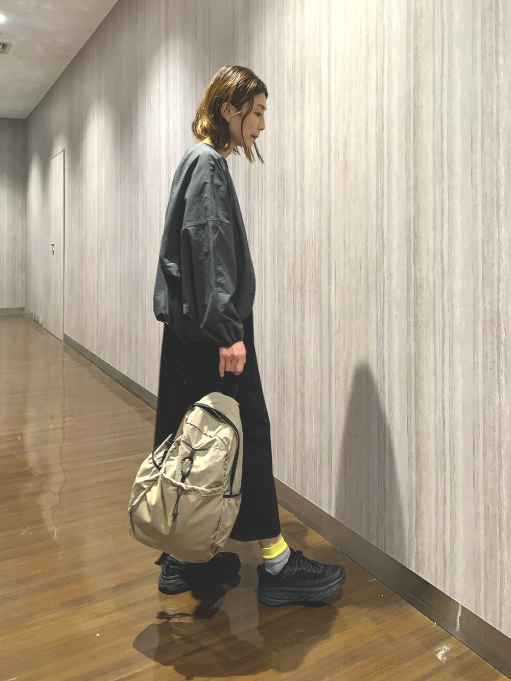 ブラック系のワンピース、グレー系のカーディガン/ボレロ、ベージュ系のバックパック/リュックを着用したレディースの春コーディネートの6枚目の写真