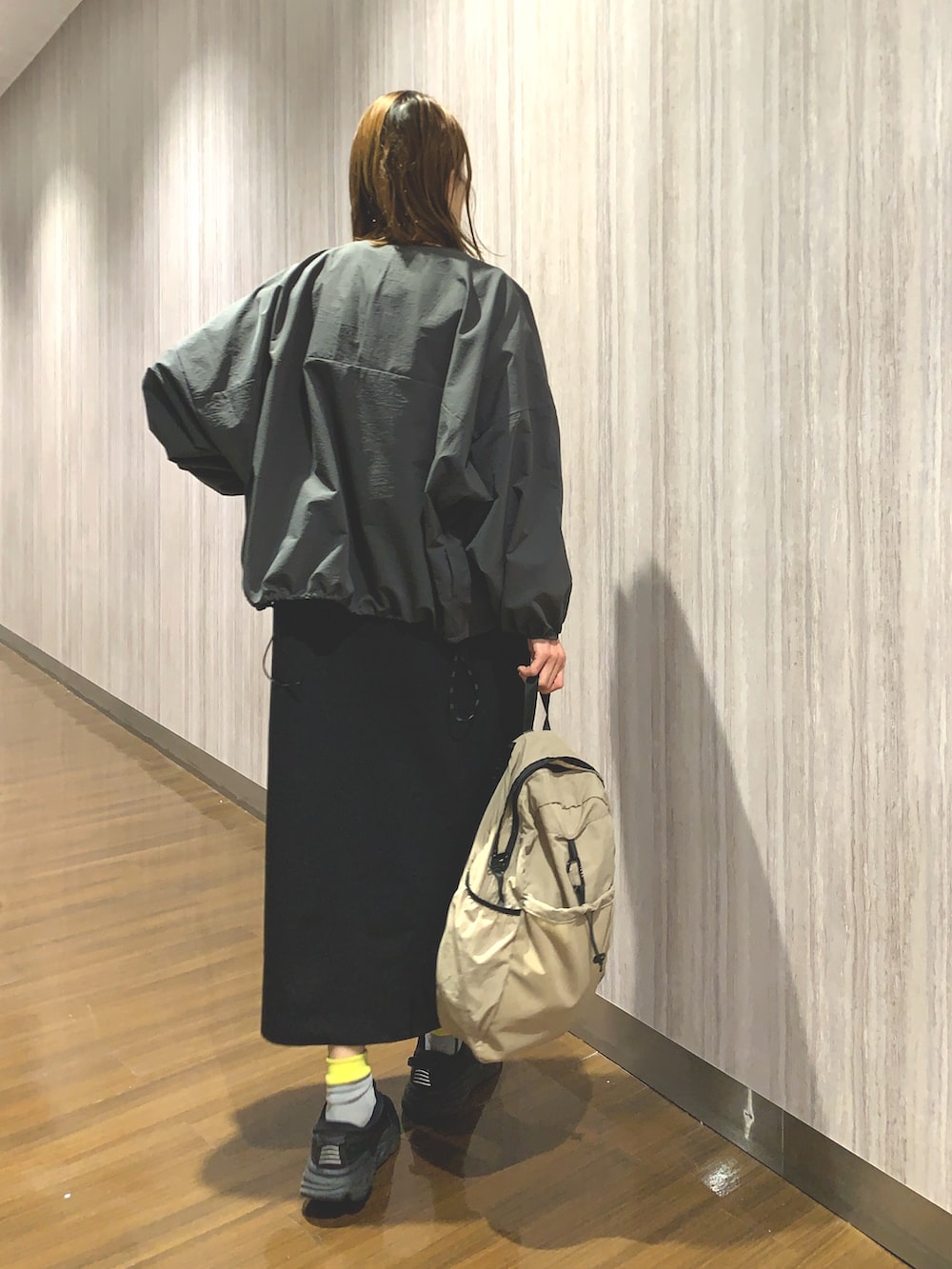 ブラック系のワンピース、グレー系のカーディガン/ボレロ、ベージュ系のバックパック/リュックを着用したレディースの春コーディネートの5枚目の写真