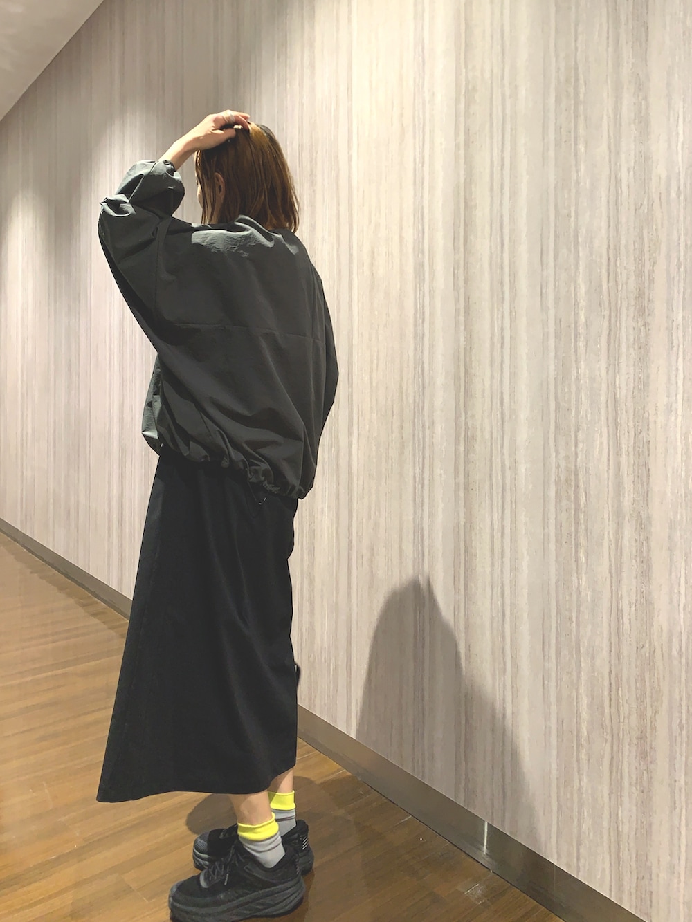 ブラック系のワンピース、グレー系のカーディガン/ボレロ、ベージュ系のバックパック/リュックを着用したレディースの春コーディネートの3枚目の写真