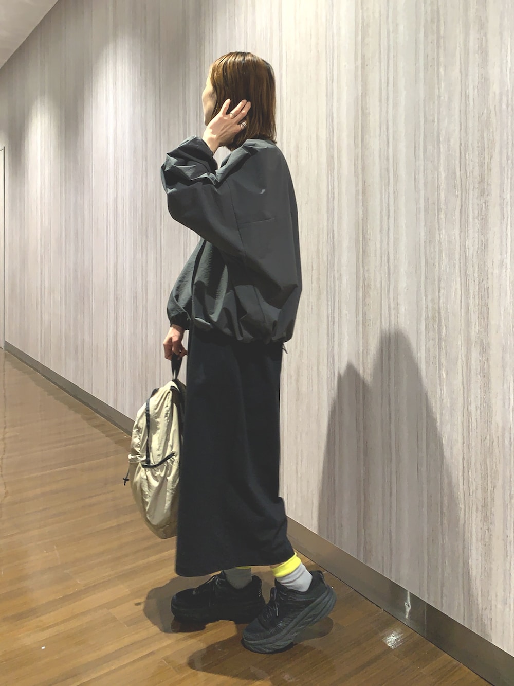 ブラック系のワンピース、グレー系のカーディガン/ボレロ、ベージュ系のバックパック/リュックを着用したレディースの春コーディネートの4枚目の写真