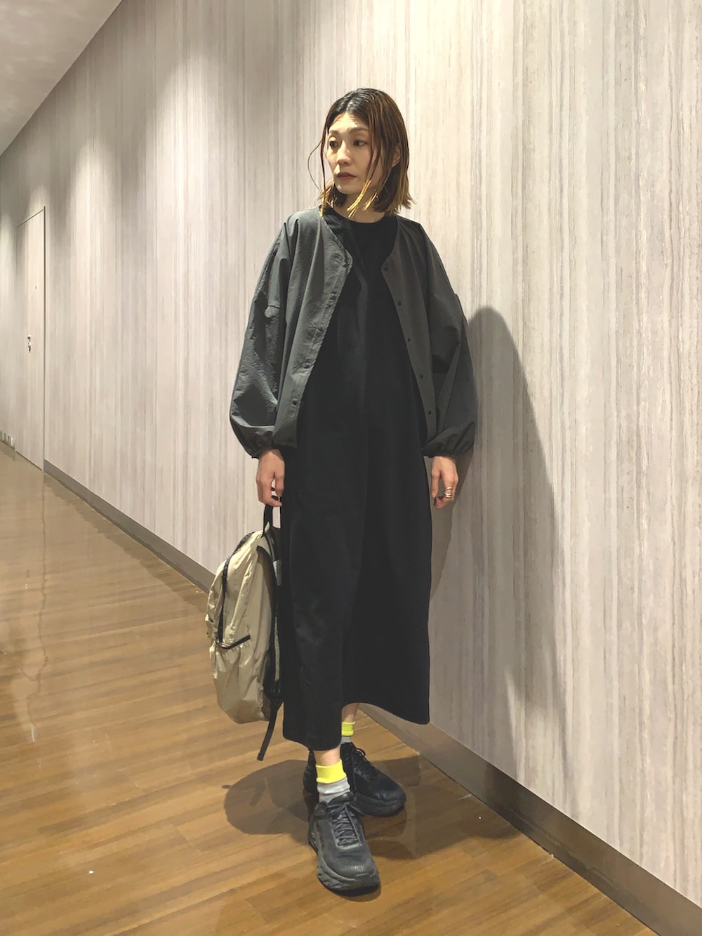 ブラック系のワンピース、グレー系のカーディガン/ボレロ、ベージュ系のバックパック/リュックを着用したレディースの春コーディネートの8枚目の写真