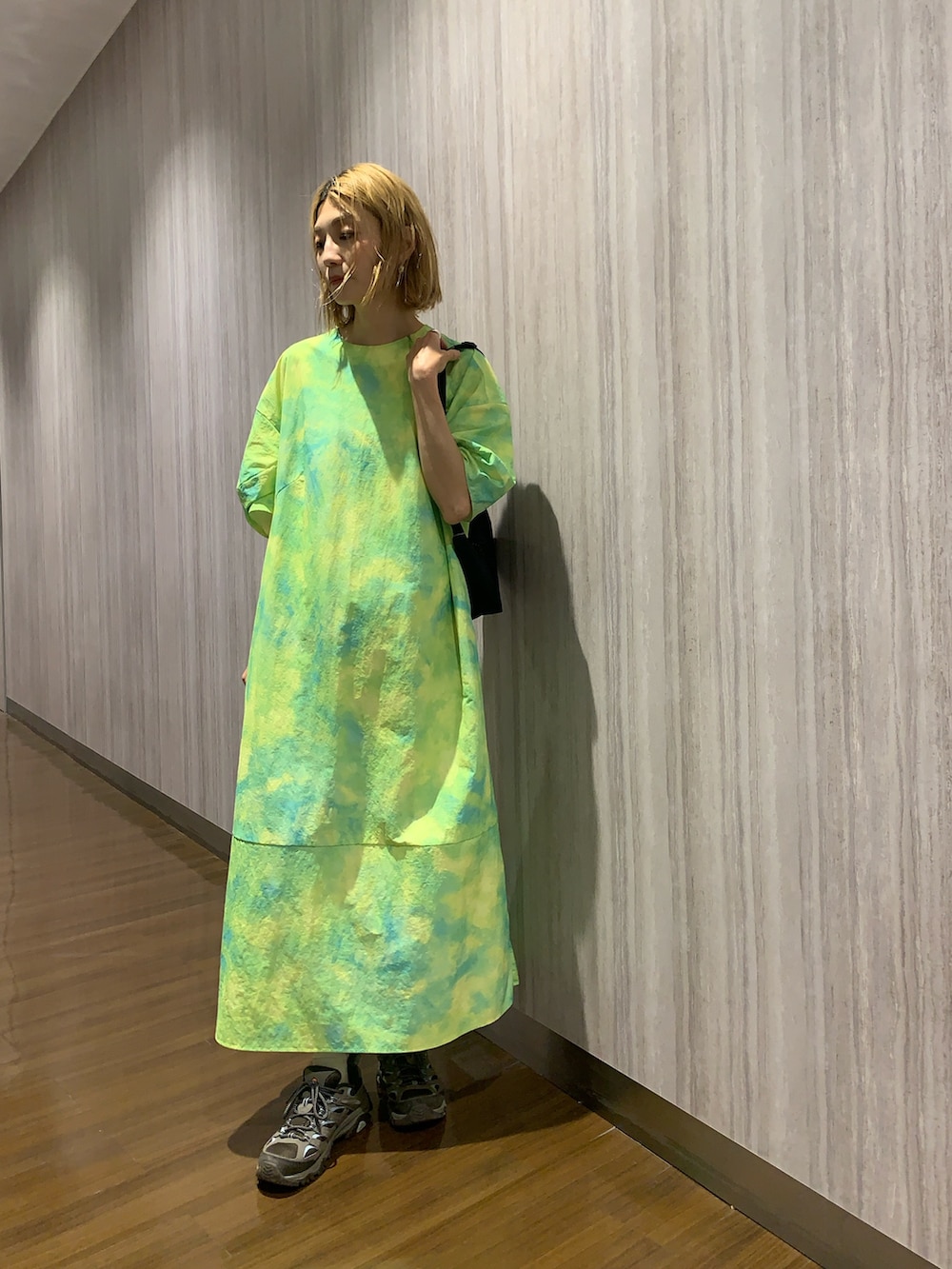 グリーン系のワンピース、ブラック系のショルダーバッグを着用したレディースの夏コーディネートの6枚目の写真