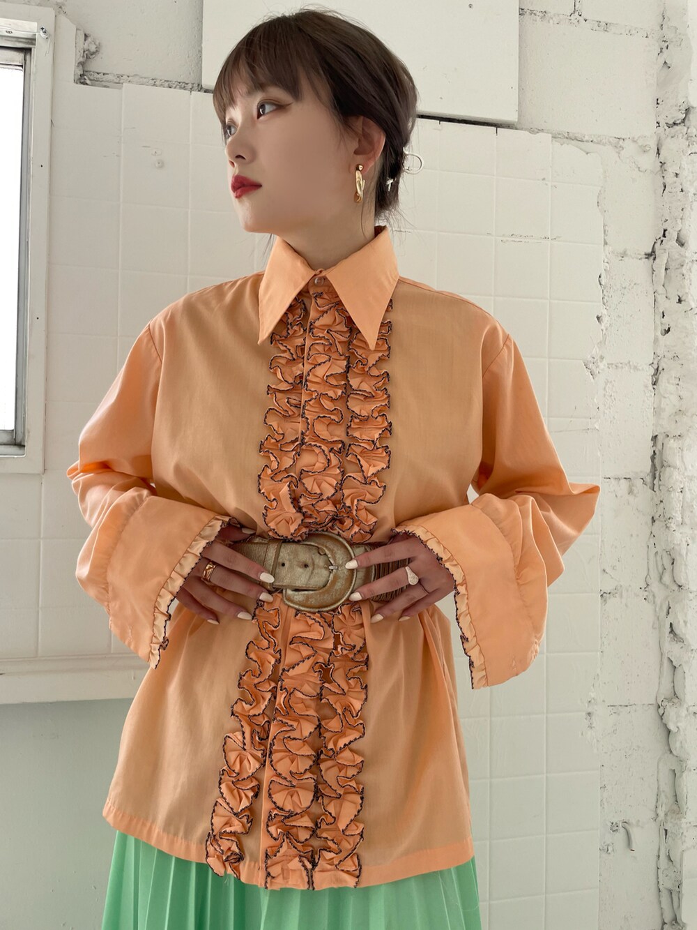 オレンジ系のトップスを着用したレディースの夏コーディネートの4枚目の写真