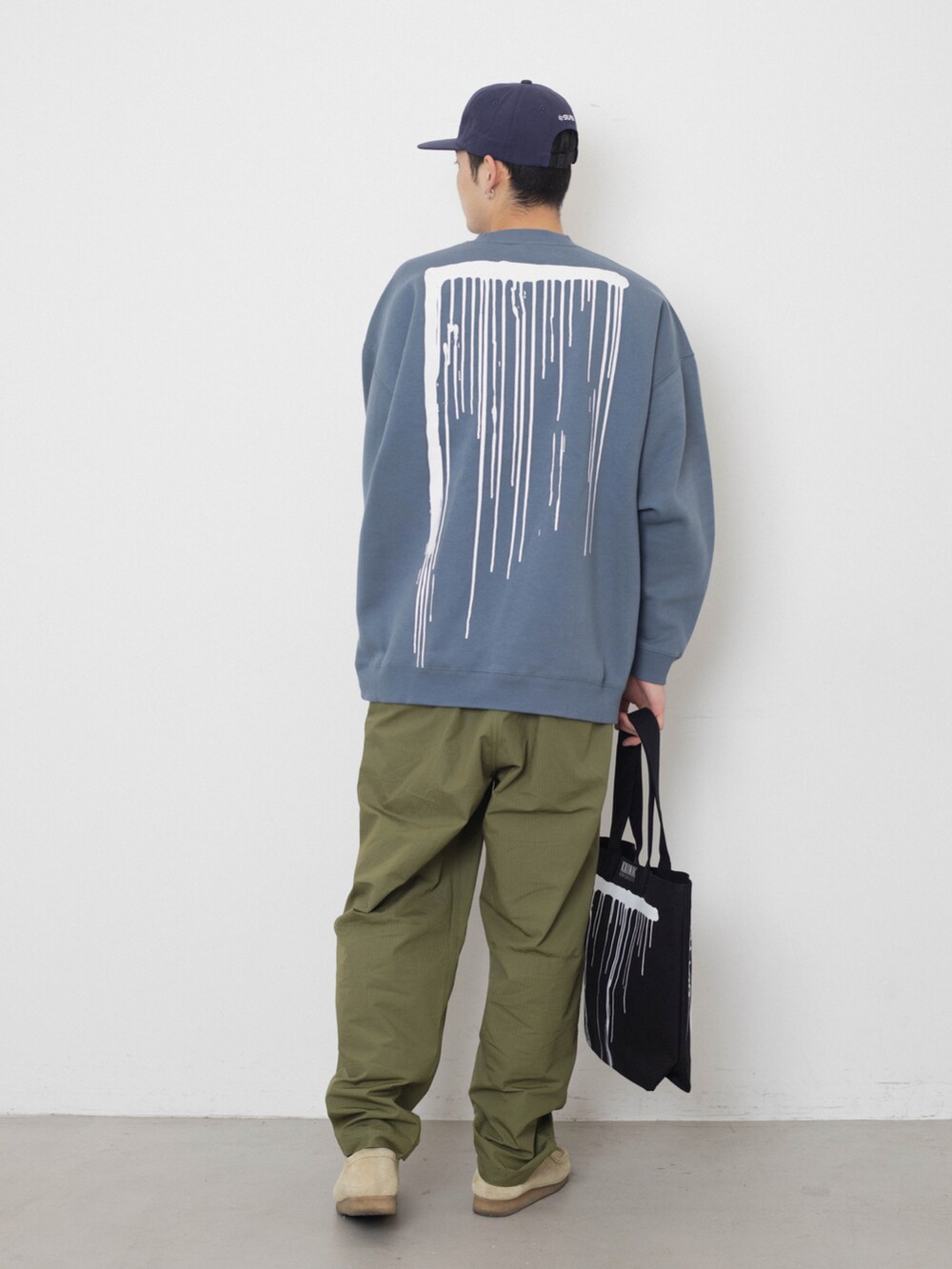 ブラック系のトートバッグ、グリーン系のその他パンツ、ブルー系のスウェットを着用したメンズの冬コーディネートの2枚目の写真