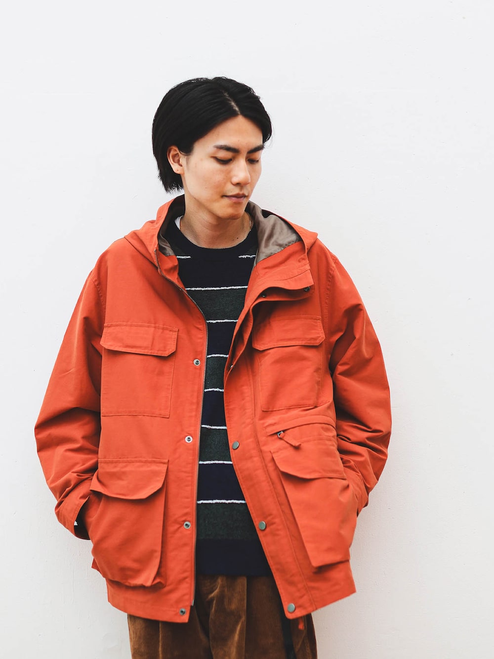 ブラウン系のその他パンツ、オレンジ系のブルゾン、ブルー系のスニーカーを着用したメンズの夏コーディネートの3枚目の写真