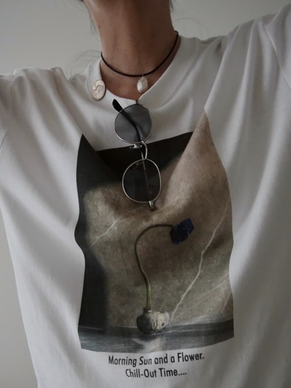 ベージュ系のその他パンツ、ホワイト系のクラッチバッグ、ブラウン系のサンダルを着用したレディースの夏コーディネートの2枚目の写真