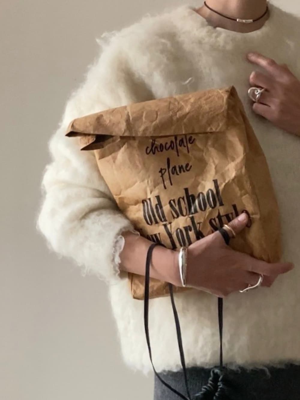 グレー系のスカート、ブラウン系のエコバッグ/サブバッグ、ブラック系のスニーカーを着用したレディースの秋コーディネートの2枚目の写真