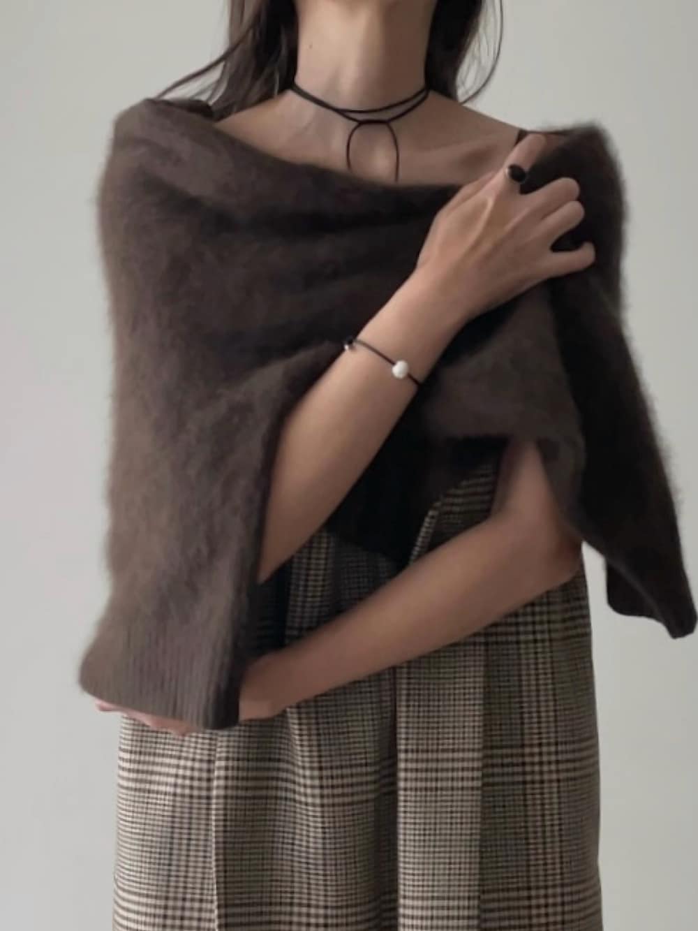 ブラウン系のニット/セーター、ベージュ系のつなぎ/オールインワン、ブラック系のハンドバッグを着用したレディースの秋コーディネートの2枚目の写真