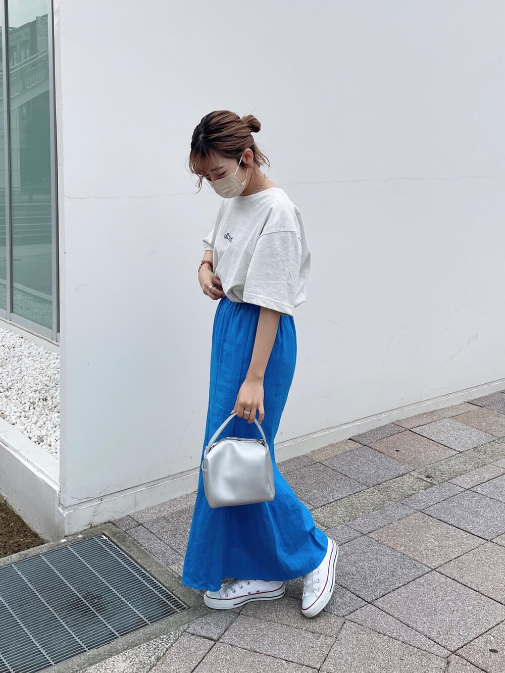 ホワイト系のTシャツ/カットソー、ブルー系のスカート、シルバー系のショルダーバッグを着用したレディースの夏コーディネートの2枚目の写真