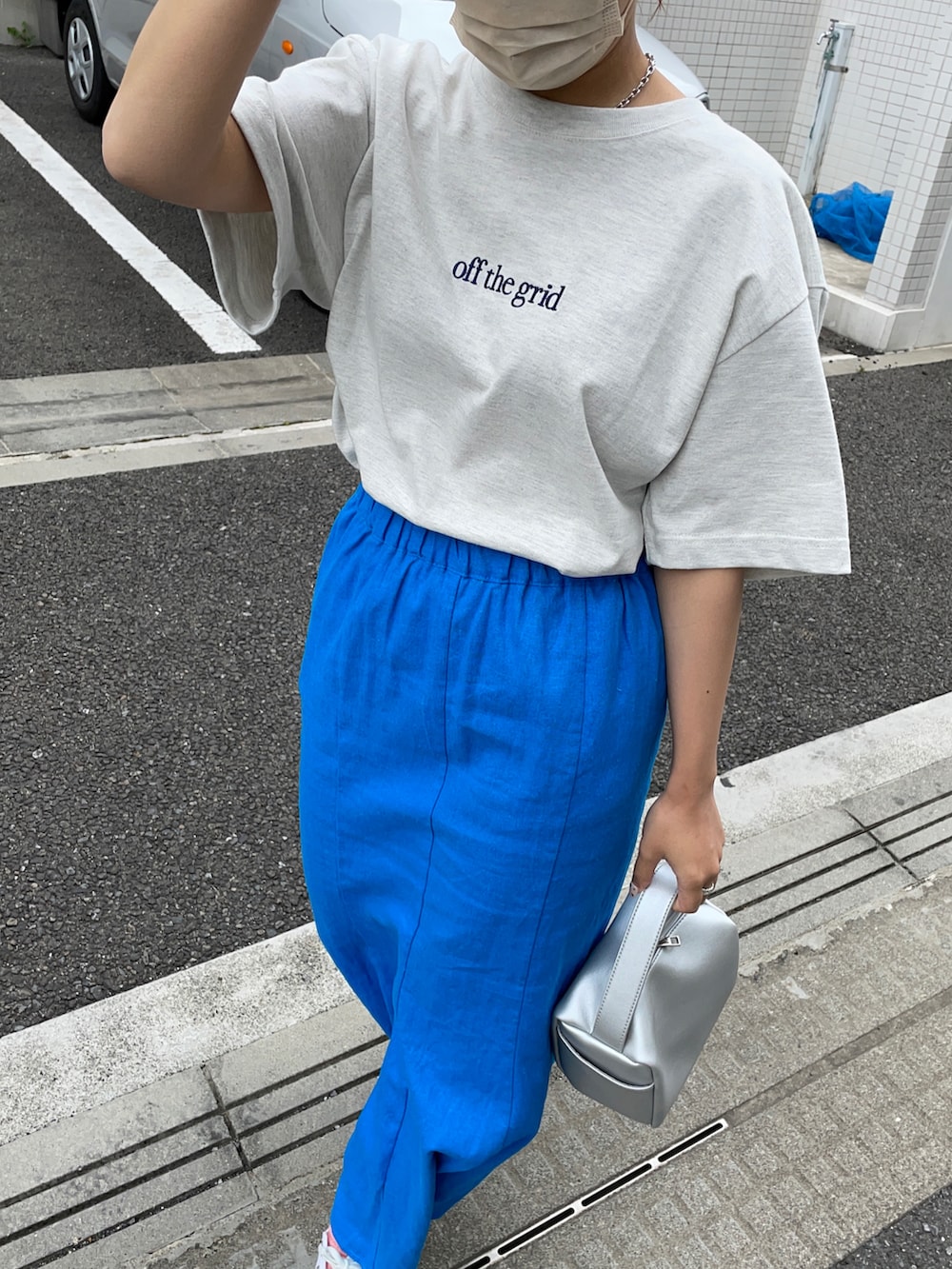 ホワイト系のTシャツ/カットソー、ブルー系のスカート、シルバー系のショルダーバッグを着用したレディースの夏コーディネートの3枚目の写真