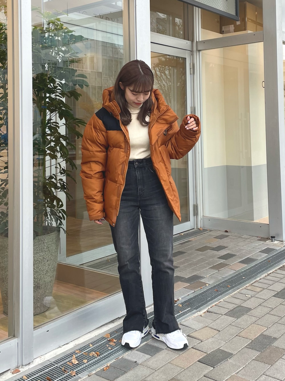 ホワイト系のニット/セーター、ブラック系のデニムパンツ、ブラウン系のダウンジャケット/コートを着用したレディースの秋コーディネートの2枚目の写真
