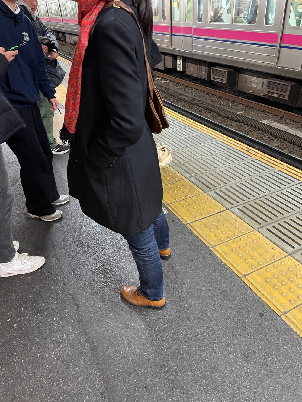 ブラック系のチェスターコート、ブラウン系のブーツを着用したメンズの冬コーディネートの2枚目の写真