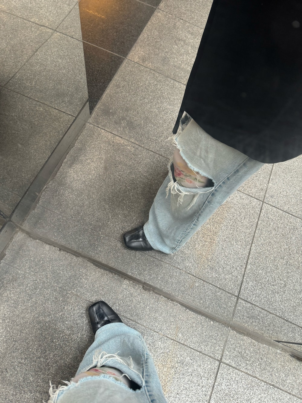 ブラック系のシューズ、ブルー系のデニムパンツ、ホワイト系のレギンス/スパッツを着用したレディースの冬コーディネートの2枚目の写真