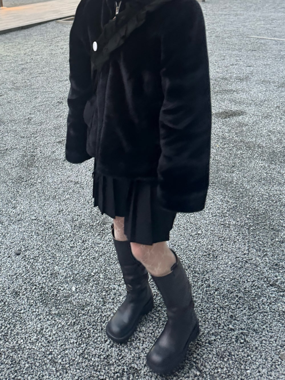 ブラウン系のブーツ、ブラック系のショルダーバッグ、ホワイト系のタイツ/ストッキングを着用したレディースの冬コーディネートの3枚目の写真