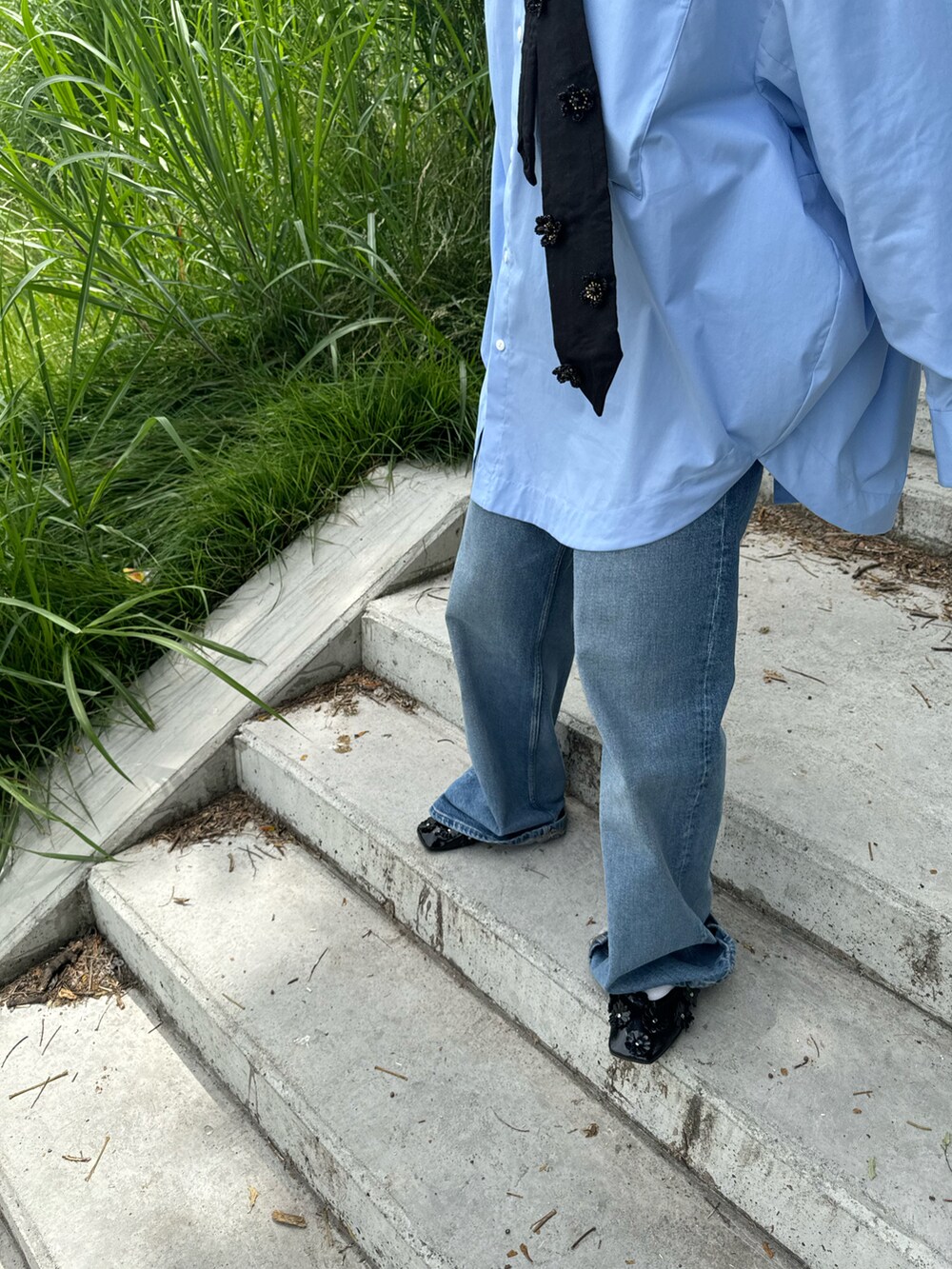 ブルー系のデニムパンツ、ブラック系のファッション雑貨を着用したレディースの夏コーディネートの3枚目の写真