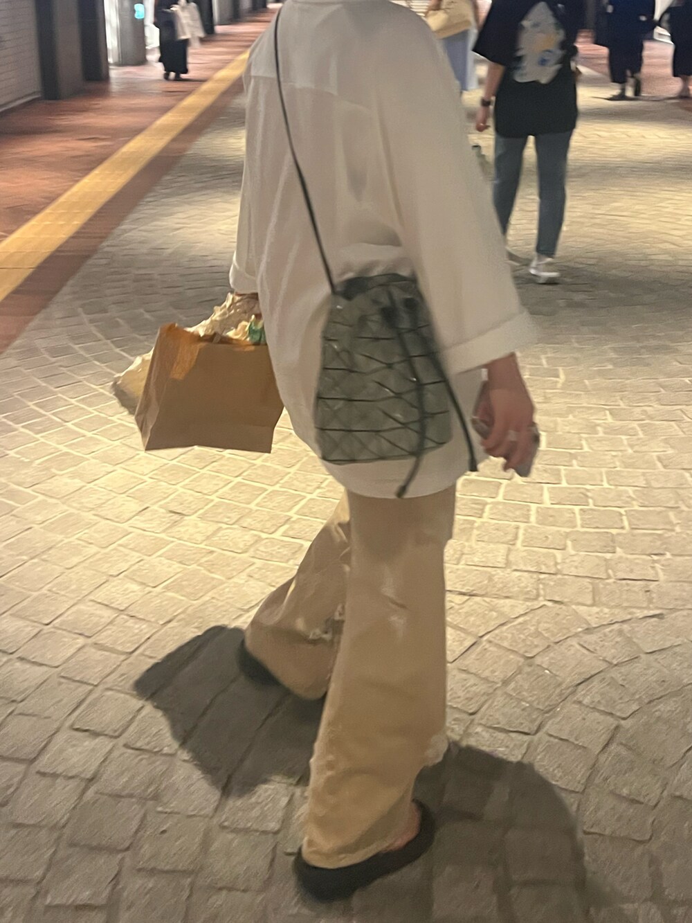 ベージュ系のデニムパンツ、ホワイト系のトップスを着用したレディースの夏コーディネートの2枚目の写真