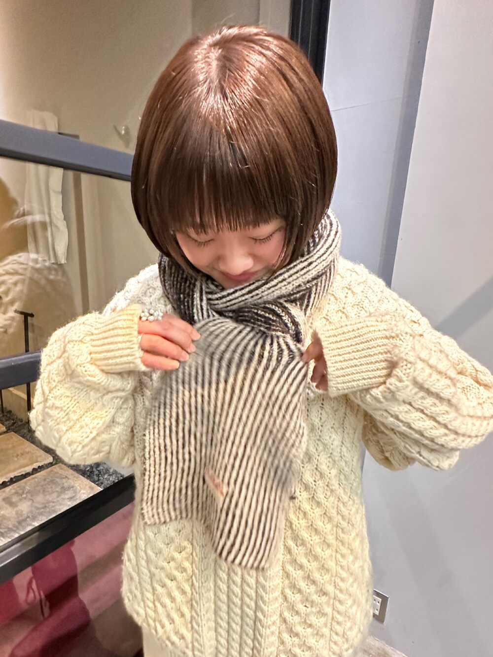 グレー系のマフラーを着用したレディースの秋コーディネートの2枚目の写真