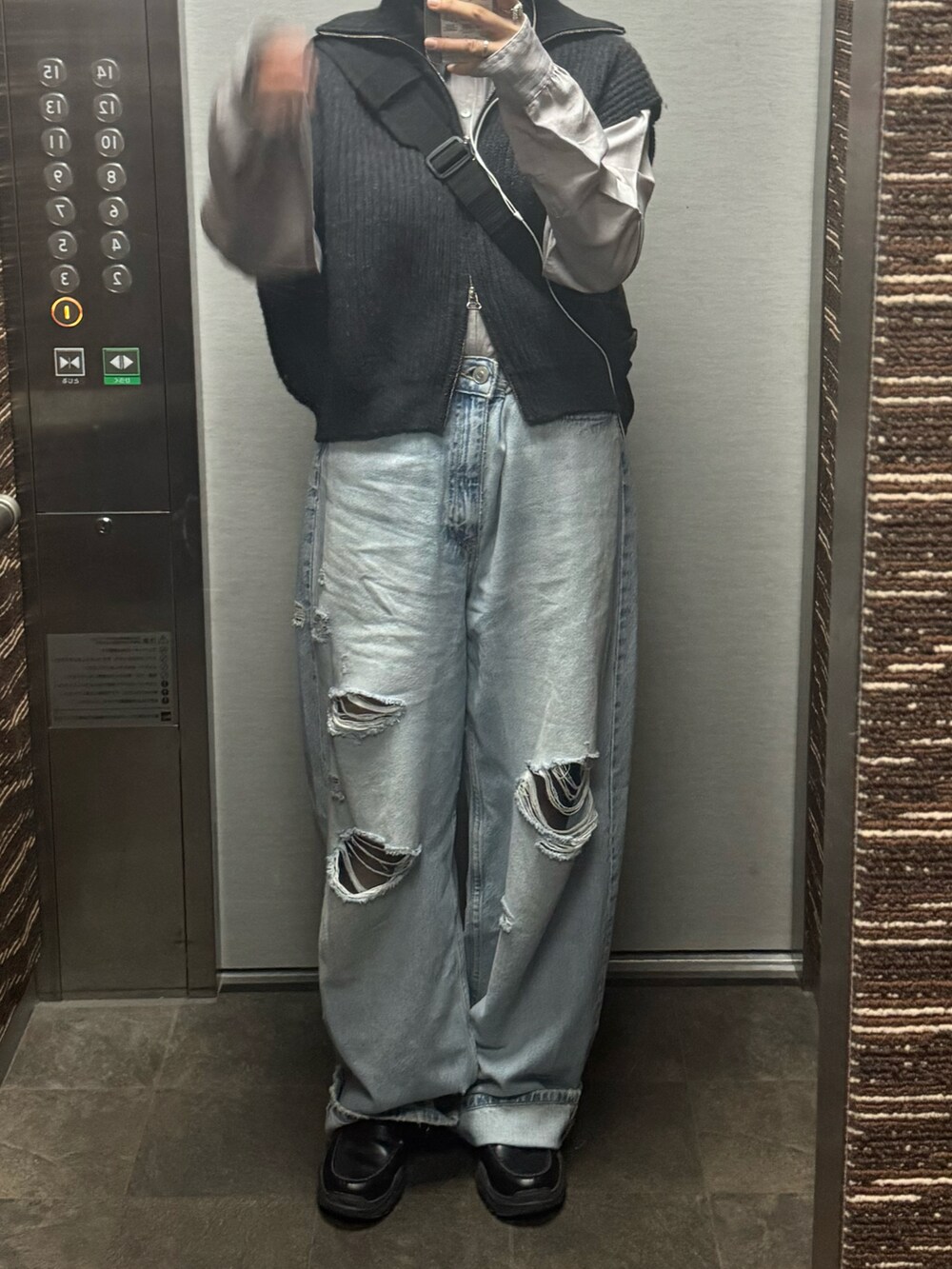 ブルー系のデニムパンツ、グレー系のシャツ/ブラウス、ブラック系のローファーを着用したレディースの春コーディネートの2枚目の写真