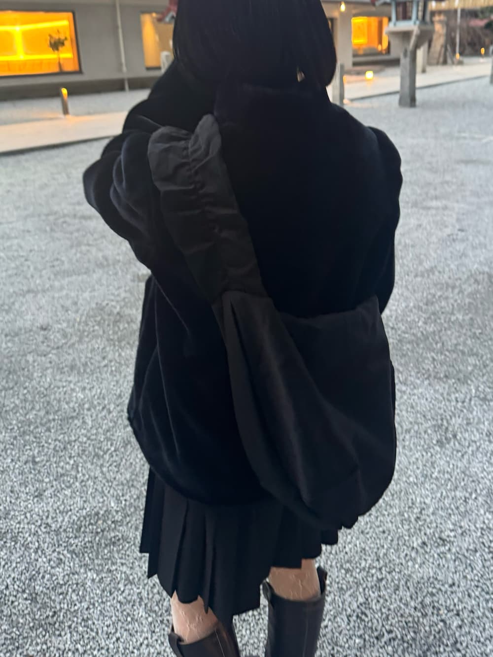 ブラウン系のブーツ、ブラック系のショルダーバッグ、ホワイト系のタイツ/ストッキングを着用したレディースの冬コーディネートの2枚目の写真