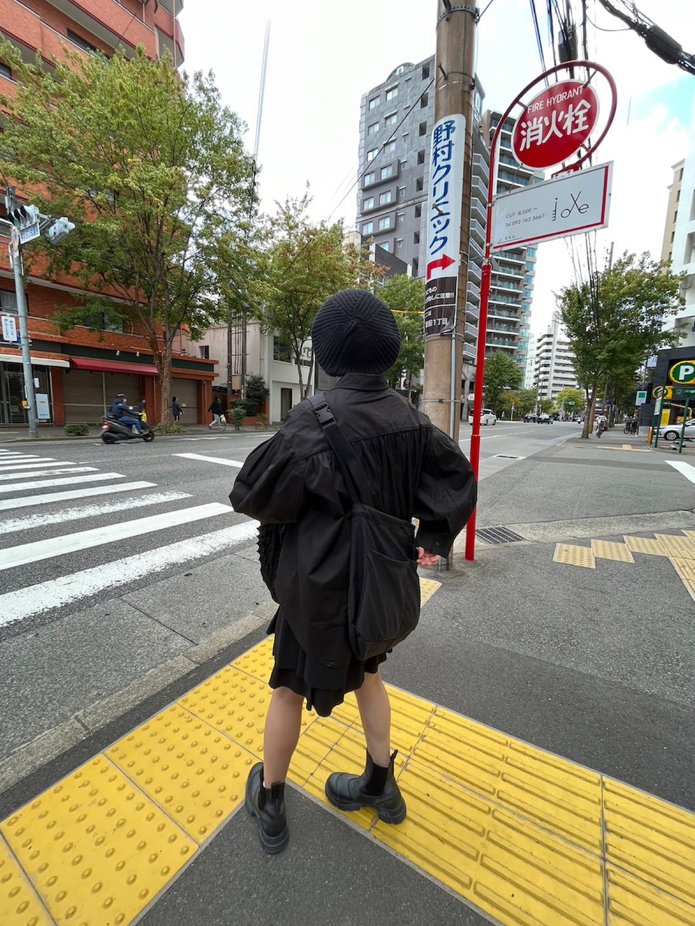 ブラック系のブーツ、ブラック系のハンドバッグ、ブラック系のシャツ/ブラウスを着用したレディースの秋コーディネートの2枚目の写真