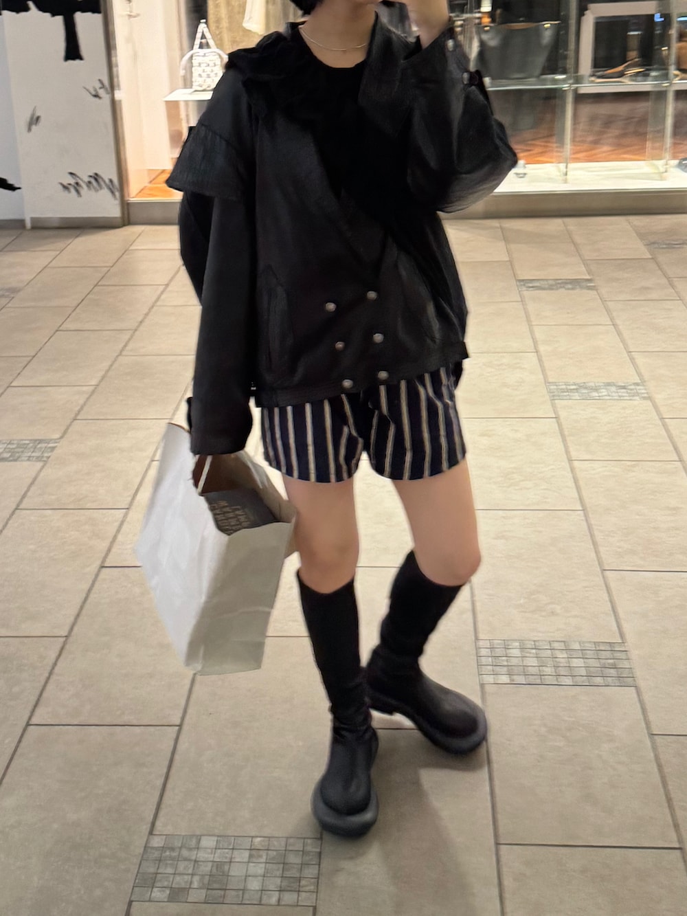 ブラック系のブーツ、ブルー系のパンツ、ブラック系のライダースジャケットを着用したレディースの秋コーディネートの2枚目の写真