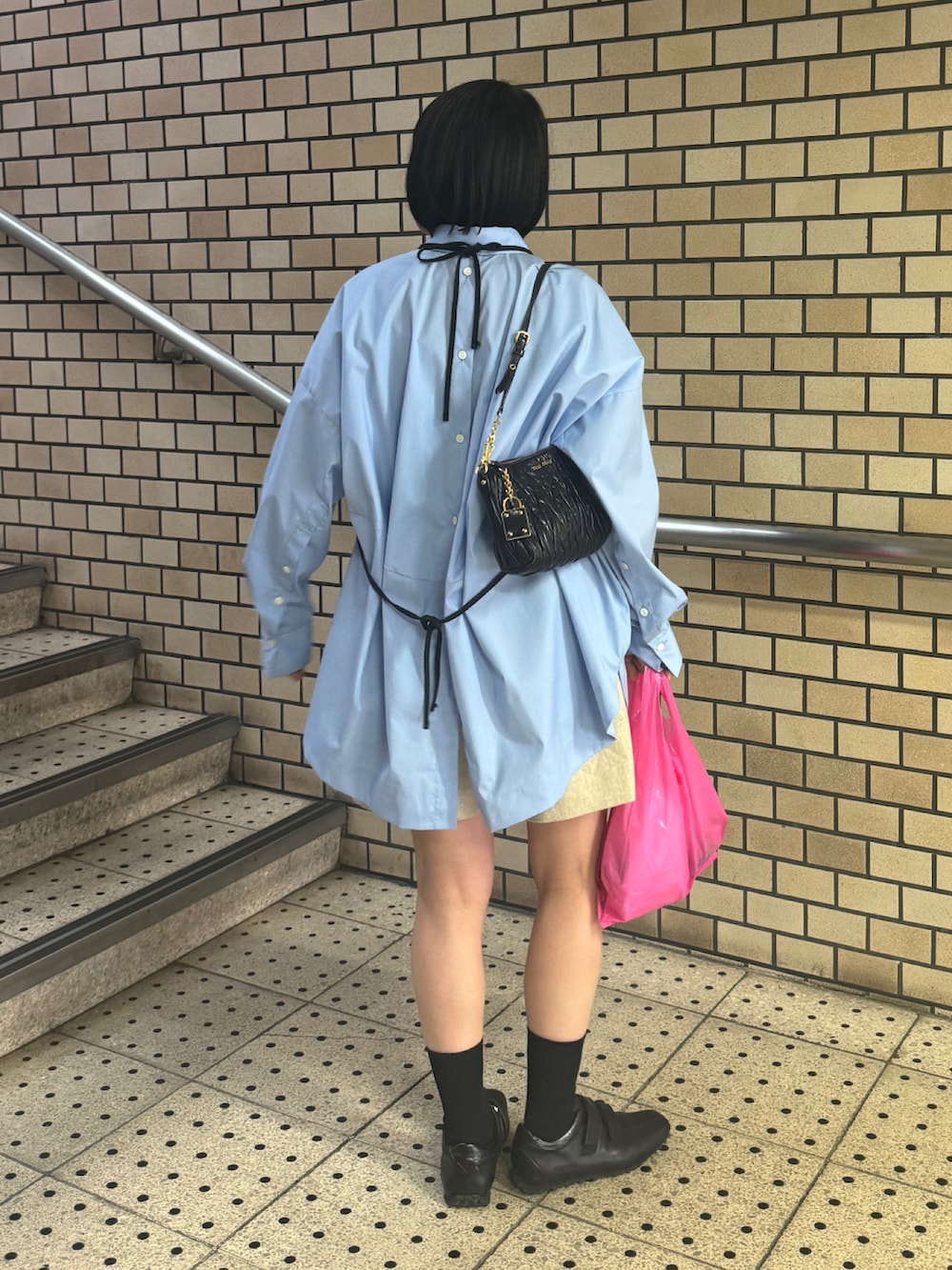 ブラック系のシューズ、ブルー系のシャツ/ブラウス、ベージュ系のパンツを着用したレディースの春コーディネートの3枚目の写真