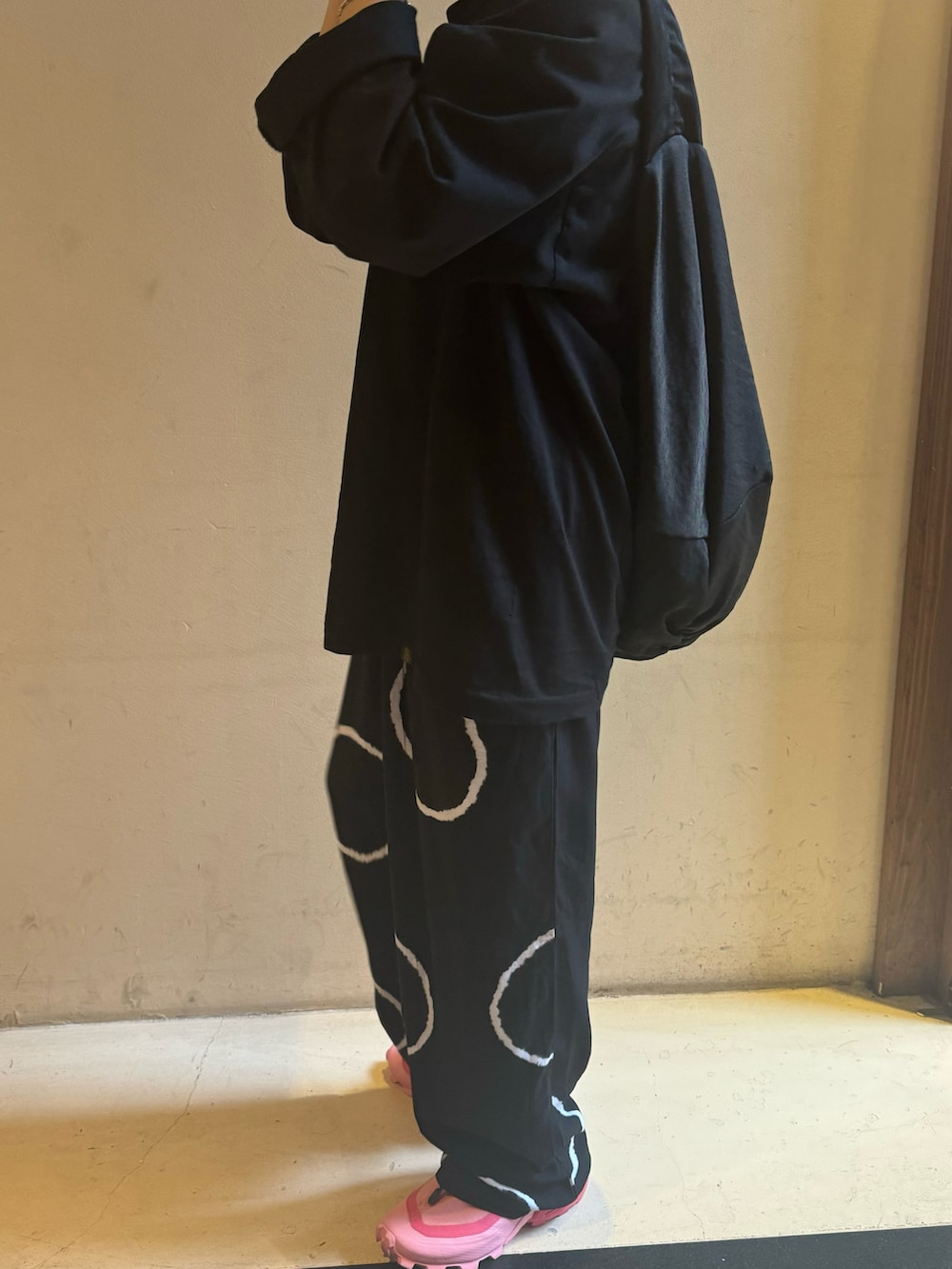 ブラック系のトップス、ブラック系のパンツ、ブラック系のショルダーバッグを着用したレディースの春コーディネートの2枚目の写真