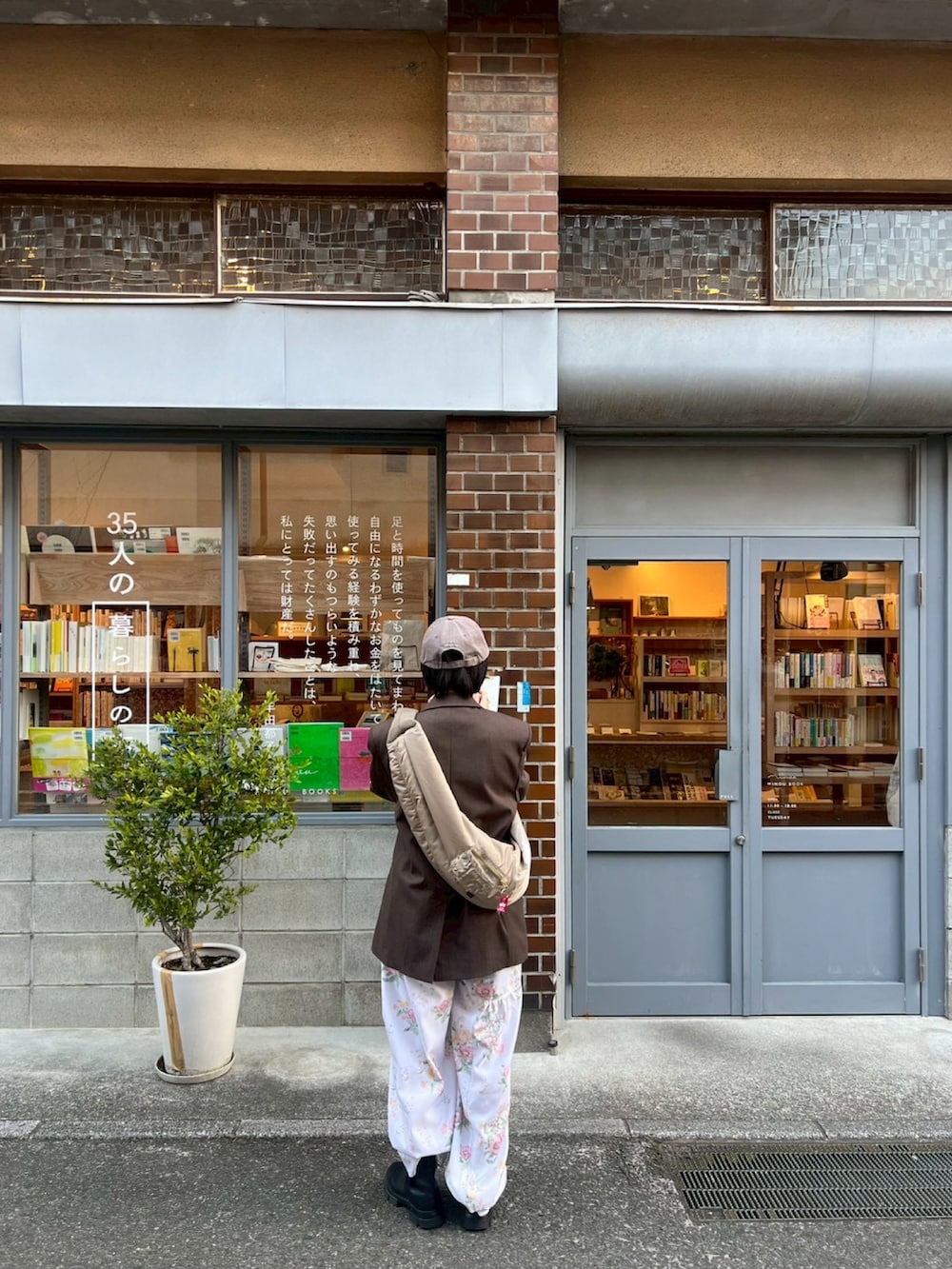 ブラック系のブーツ、ブラウン系のテーラードジャケット、グレー系のキャップを着用したレディースの冬コーディネートの2枚目の写真