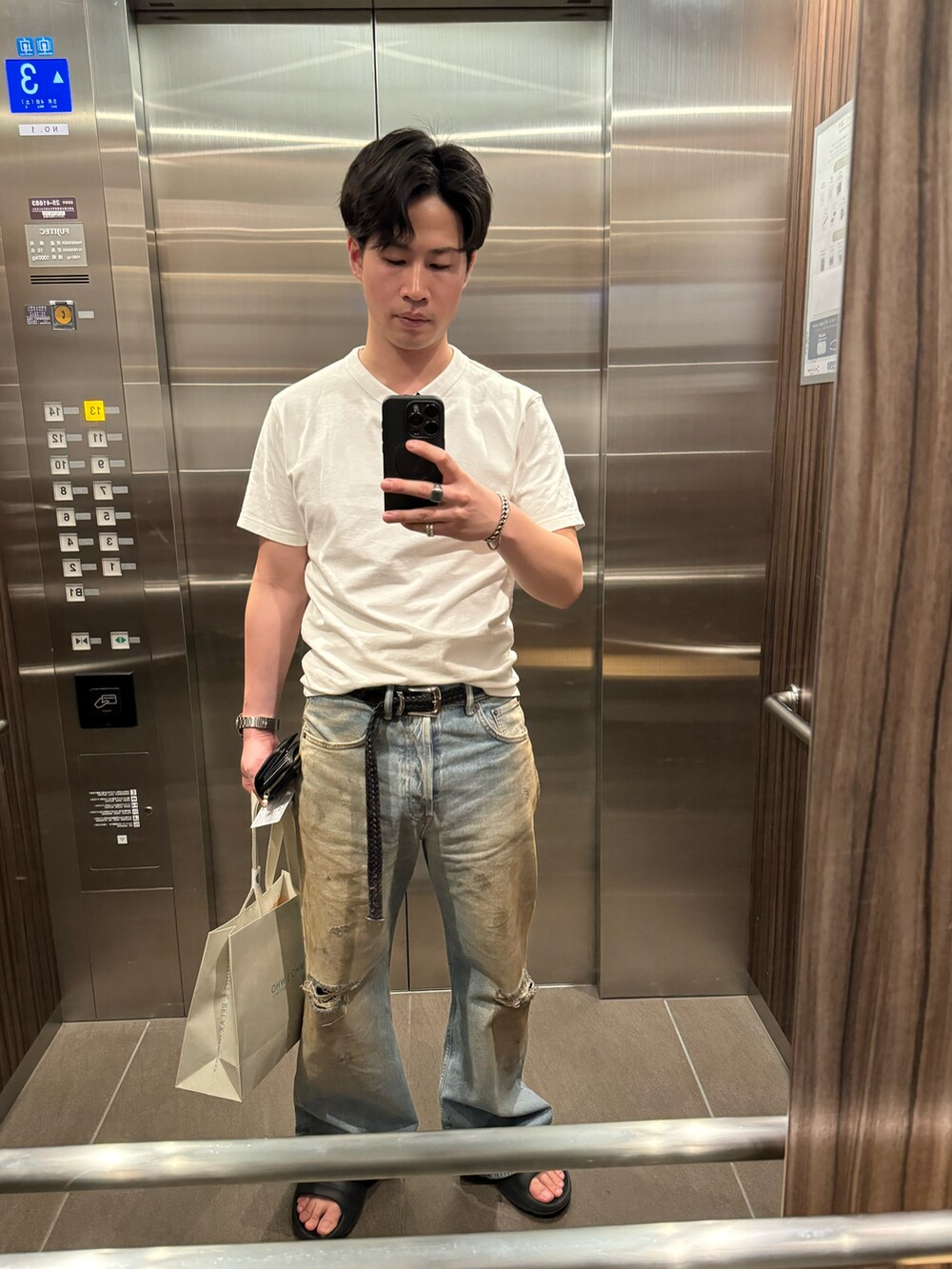 ホワイト系のTシャツ/カットソー、ブルー系のデニムパンツ、ブラック系のサンダルを着用したメンズの春コーディネートの2枚目の写真