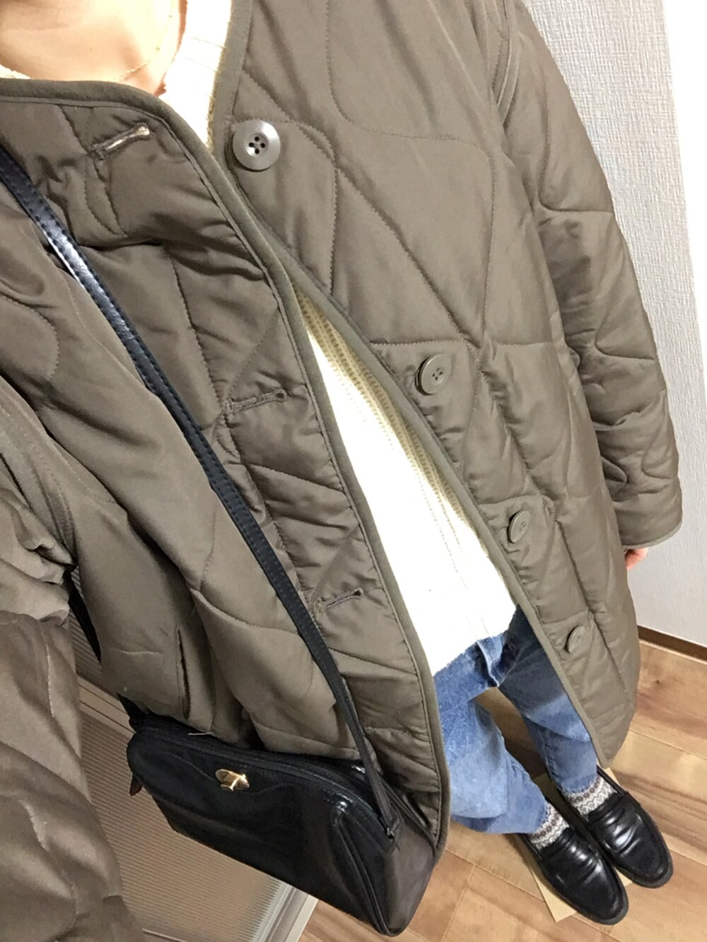 ブラック系のローファー、ブルー系のデニムパンツ、ホワイト系のニット/セーターを着用したレディースの冬コーディネートの2枚目の写真