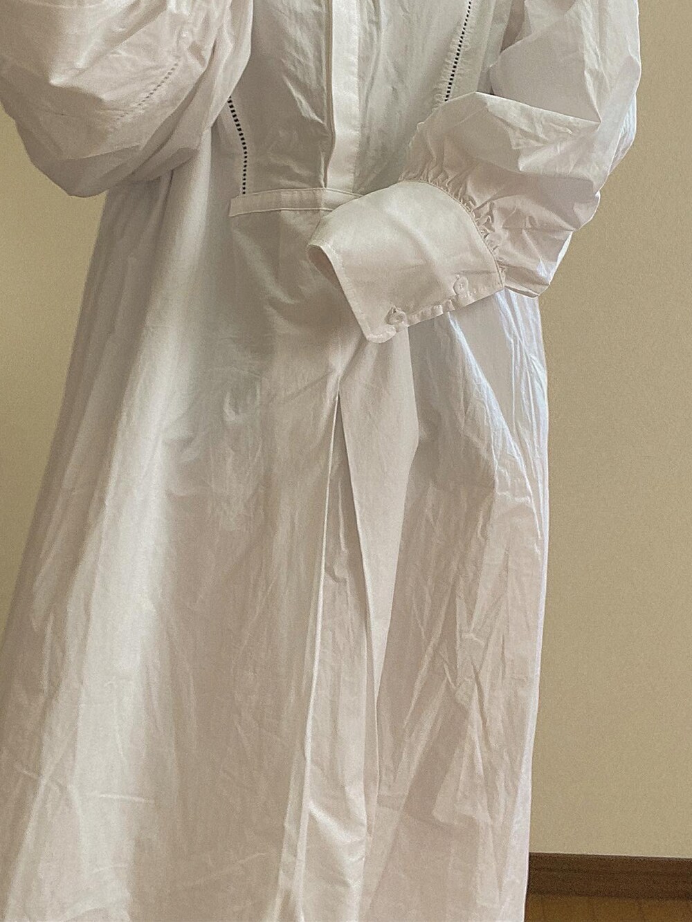 ホワイト系のシャツワンピース、ブラック系のブーツを着用したレディースの冬コーディネートの3枚目の写真