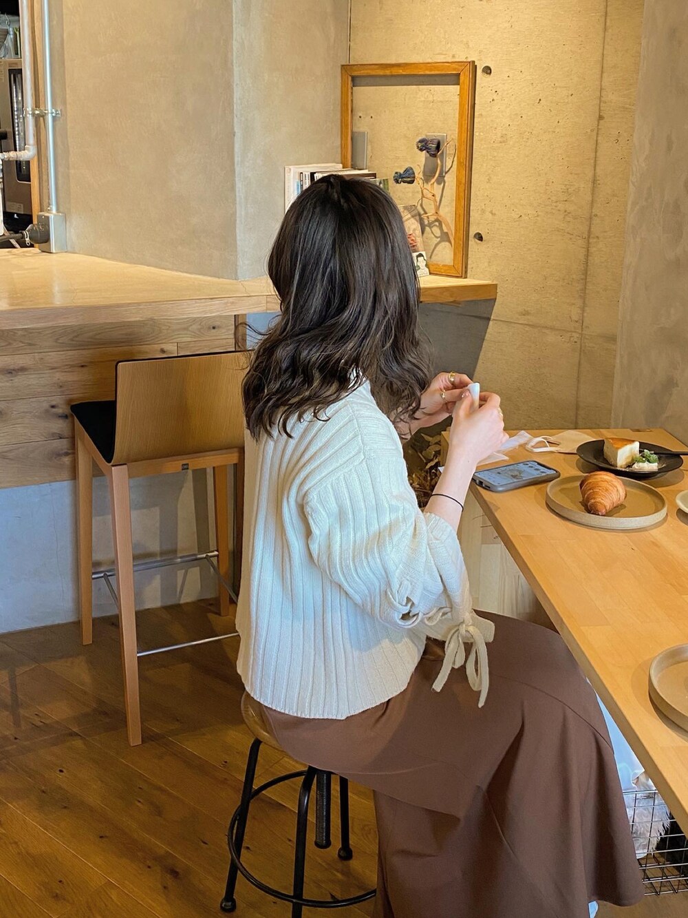 ベージュ系のニット/セーター、ホワイト系のベスト、ブラウン系のスカートを着用したレディースの冬コーディネートの2枚目の写真