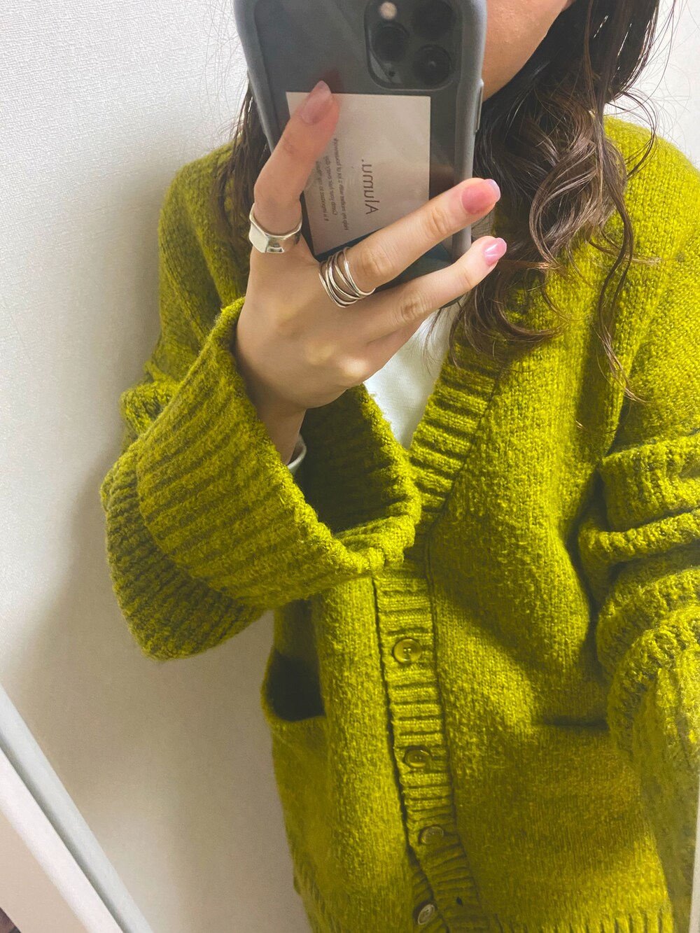 グリーン系のカーディガン/ボレロ、ベージュ系のTシャツ/カットソー、ホワイト系のスカートを着用したレディースの冬コーディネートの3枚目の写真