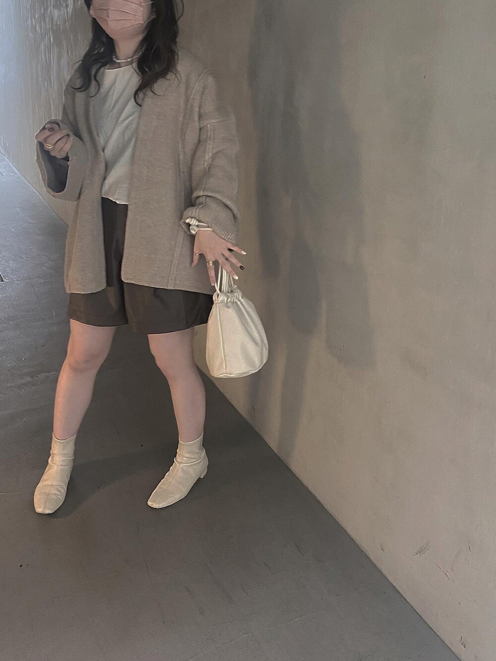 ベージュ系のノーカラーコート、ブラウン系のその他パンツ、ホワイト系のブーツを着用したレディースの秋コーディネートの2枚目の写真