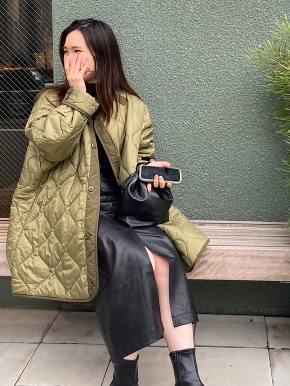 グリーン系のノーカラージャケット、ブラック系のスカート、ブラック系のショルダーバッグを着用したレディースの冬コーディネートの3枚目の写真