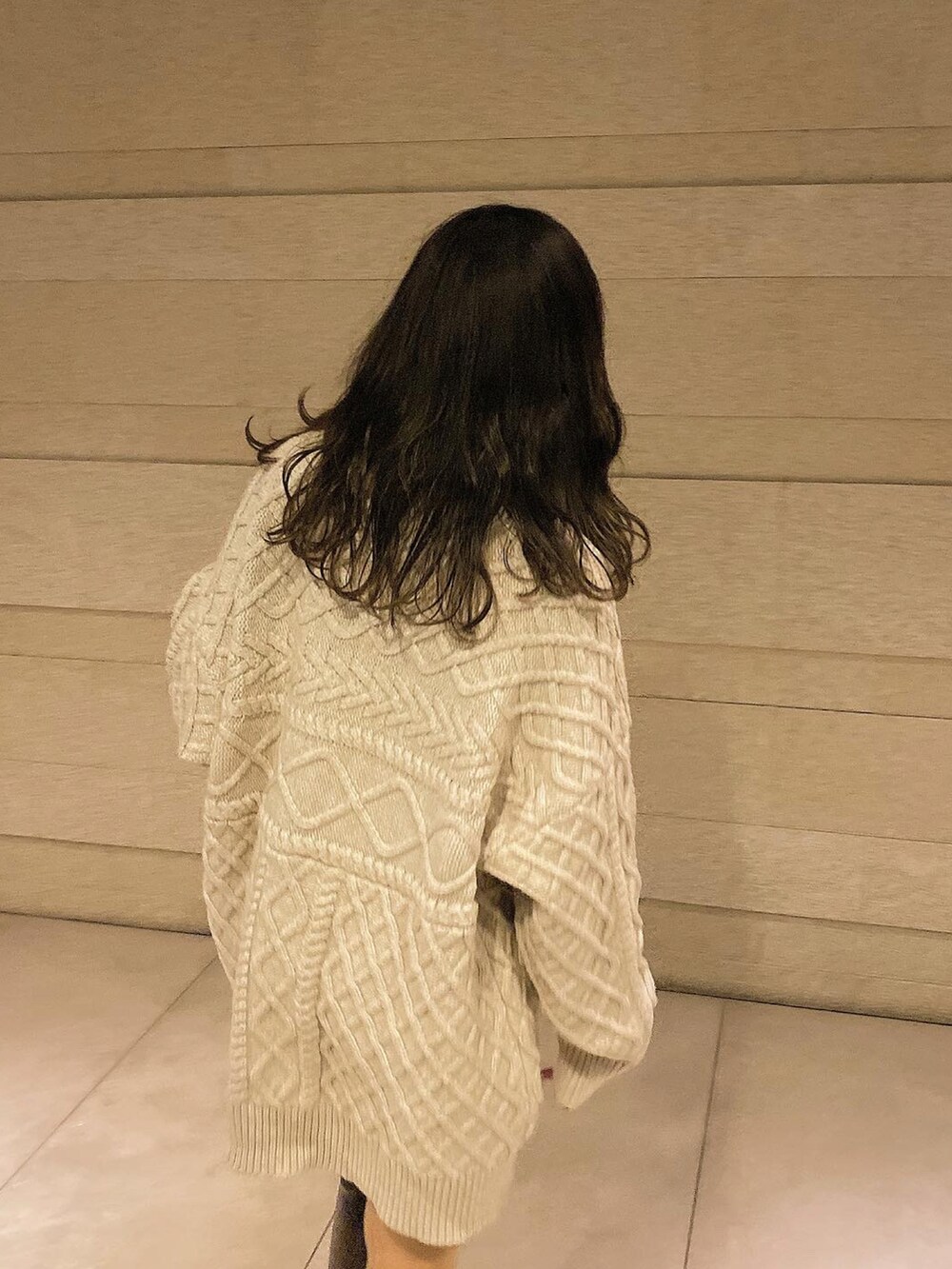 ブラウン系のブーツ、ブラウン系のボストンバッグ、ホワイト系のニット/セーターを着用したレディースの冬コーディネートの4枚目の写真